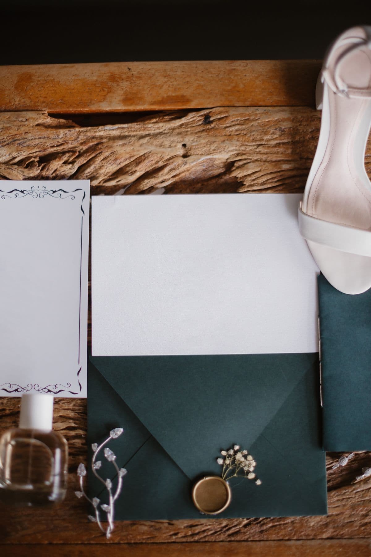 Invitación de boda con sobre verde salvia sobre madera